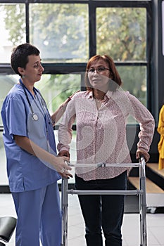 Health specialist supporting senior woman to walk