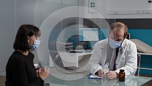 Health specialist taking notes at checkup appointment with patient