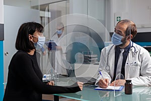 Health specialist taking notes at medical consultation in office