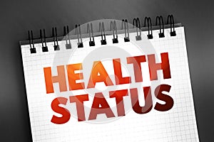 Health Status - individual\'s relative level of wellness and illness, text on notepad, concept background