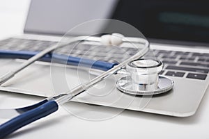 Health stethoscope on keyboard of laptop computer