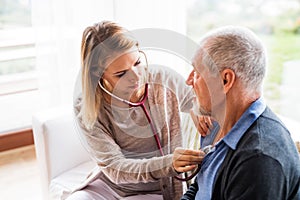 Health visitor and a senior man during home visit.