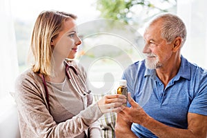 Health visitor and a senior man during home visit.