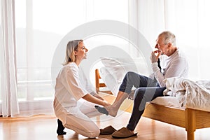 Health visitor and senior man during home visit.