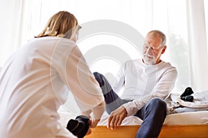 Health visitor and senior man during home visit.