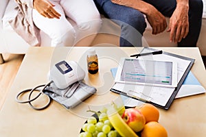 Health visitor and a senior man with tablet during home visit.