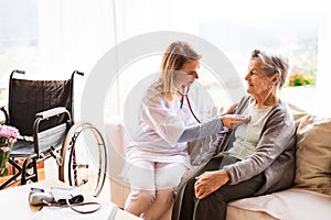 Health visitor and a senior woman during home visit.