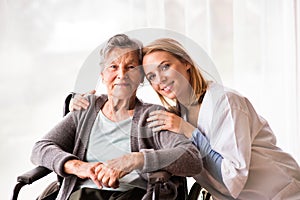 Health visitor and a senior woman during home visit.