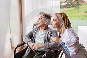 Health visitor and a senior woman during home visit.