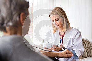 Health visitor and a senior woman during home visit.