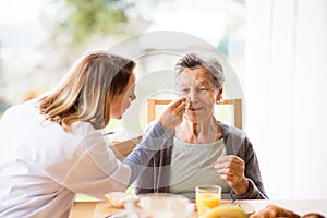 Health visitor and a senior woman during home visit.