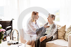 Health visitor and a senior woman during home visit.