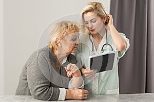 Health visitor and a senior woman during home visit.