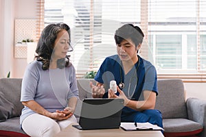 Health visitor and a senior woman with tablet during home visit. Elderly healthcare and Home health care service concept