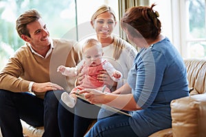 Health Visitor Talking To Family With Young Baby