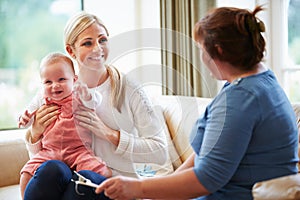 Health Visitor Talking To Mother With Young Baby