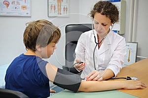Health worker measures the pressure of the boy in photo