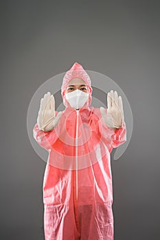 Health worker wear personal protective equipment with two palms forward as a stop gesture