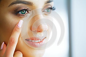 Health. Young Girl Holds Contact Lens In Hands. Portrait of a Beautiful Woman with Green Eyes and Contact Lenses