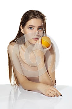 Healthcare. Beautiful young woman with orange over white background. Cosmetics and makeup, natural and eco treatment
