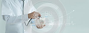 Healthcare business graph and Medical examination, Abstract doctor holding stethoscope and piggy bank in hands and analyzing data