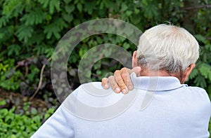 Healthcare concept. Asian Older man suffering from shoulder pain sitting on chair. Health problem retired asian old man hands