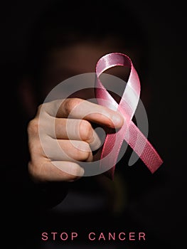 Healthcare concept - child hands holding cancer awareness ribbon