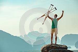 Healthcare concept with disabled man standing on big rock