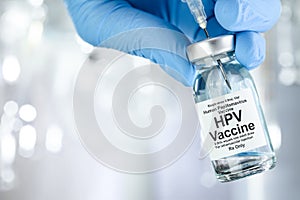 Healthcare concept with a hand in blue medical gloves holding HPV vaccine vial