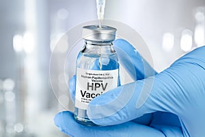 Healthcare concept with a hand in medical gloves holding HPV, human papillomavirus, vaccine vial photo