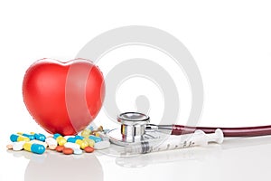 Healthcare concept with medicine pills, caplet, tablet, capsule and red heart, stethoscope, syringe as prop