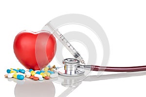 Healthcare concept with medicine pills, caplet, tablet, capsule and red heart, stethoscope, syringe as prop