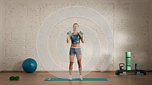 Healthcare creative advertisement concept. Woman fitness coach in the room holding dumbbells on shoulders.