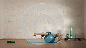 Healthcare creative advertisement concept. Woman fitness coach in the room stretching her back on a ball.