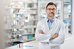 Healthcare, crossed arms and portrait of a male pharmacist standing in a pharmacy clinic. Pharmaceutical, medical and