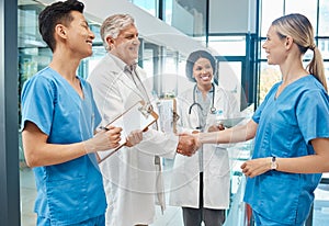 Healthcare, doctor and nurse handshake in a hospital to welcome or celebrate success. Men and women medical group