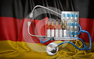 Healthcare, insurance and pharmacy in Germany concept. Pills, vaccine, syrringe and stethoscope in German flag