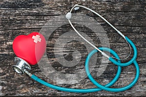 Healthcare insurance and world health day concept with red heart with cross bandage and medical doctor stethoscope