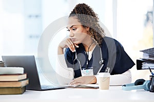 Healthcare, laptop and research with a woman nurse reading information in a hospital for diagnosis. Medical, insurance