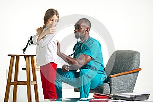 Healthcare and medical concept - doctor with stethoscope listening to child chest in hospital