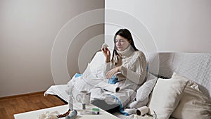 Healthcare and medical concept.Young sick woman sneezing at home at night on the couch. Girl runny nose and holding