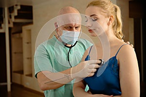 Healthcare and medical examination concept - doctor with woman patient at home - Stethoscope listen hearbeat - Green