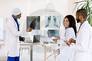 Healthcare, medical: Group of African doctors discuss and looking x-ray in a clinic or hospital. African man chief