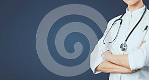 Healthcare Medical Insurance Concept. Female Doctor With Stethoscope With Crossed Arms On Blue Background With Copy Space