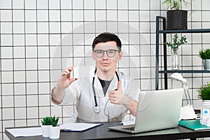 Healthcare, medical and pharmacy concept - male doctor with packs of pills