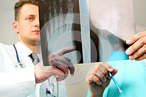 Healthcare, medical and radiology concept - Male doctors looking at x-ray of foot