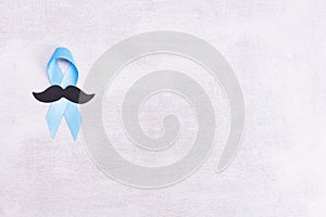 Healthcare and medicine concept - blue prostate cancer awareness ribbon and paper black mustache, achalasia and adrenocortical photo