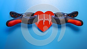 Healthcare and medicine concept - close up of a red heart with an ecg line clamped in a vise for resuscitation. Salvation of life