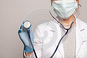 Healthcare and medicine concept. Doctor hand in blue medical glove holding stethoscope