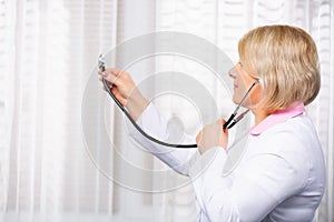 Healthcare and medicine concept. Profile photo of female doctor or nurse with stethoscope diagnosise in invisible empty